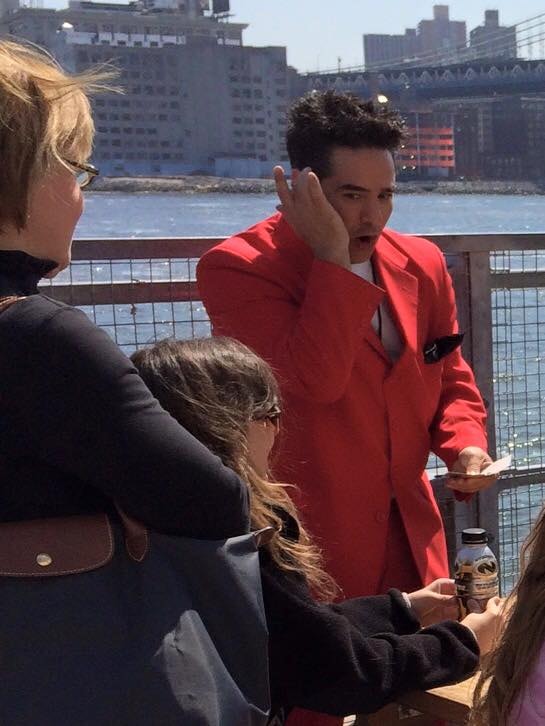 Professional stage magician performing dramatic close-up magic